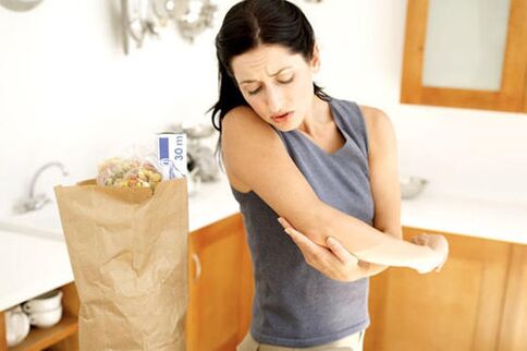 girl examines psoriasis on the elbow